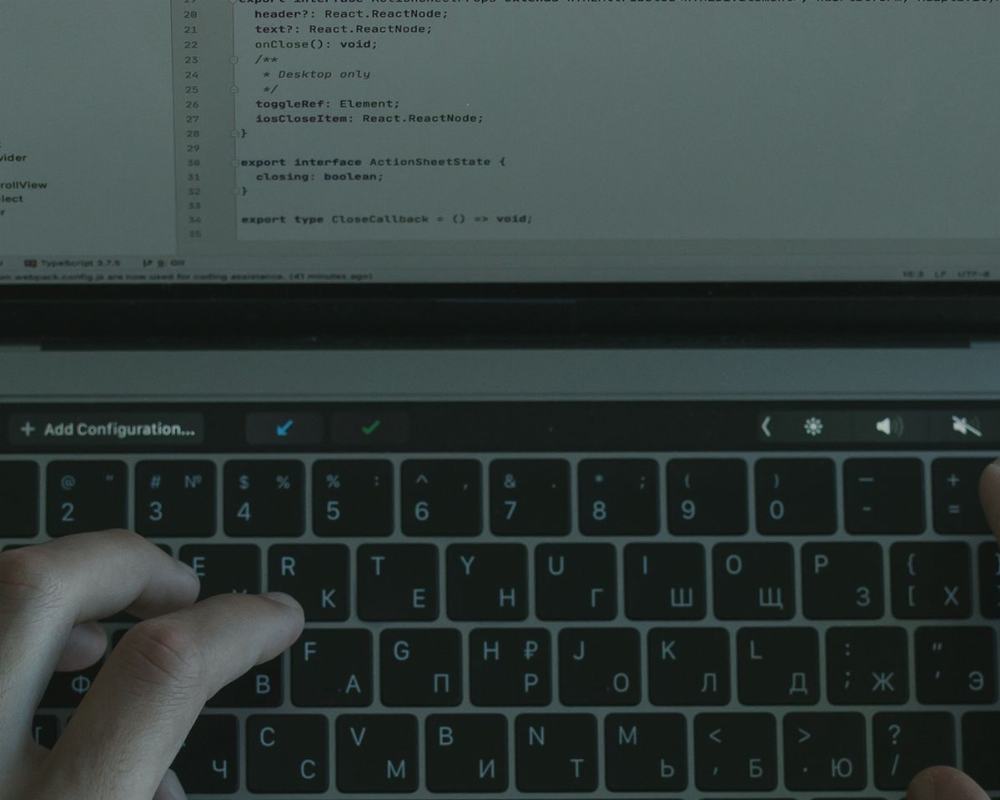 Hands typing code on a laptop