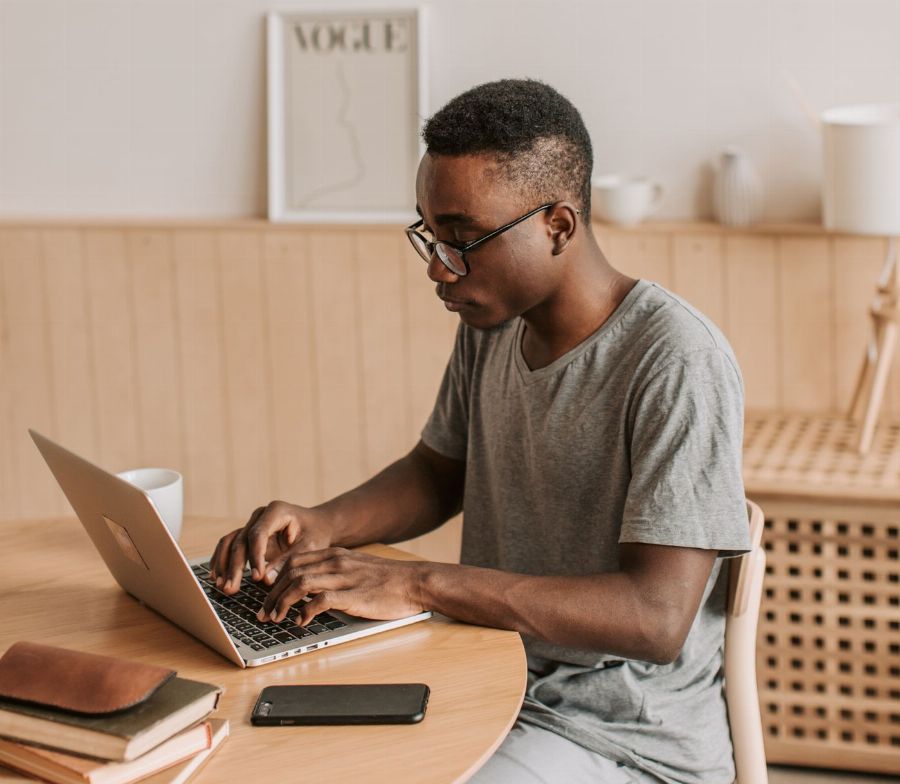 Man typing on his laptop at a table
